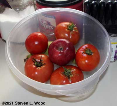 An apple and a banana helping tomatoes ripen