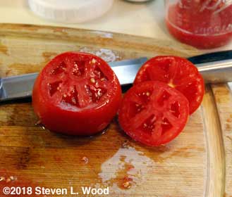 Cutting tomato to reveal seed cavities