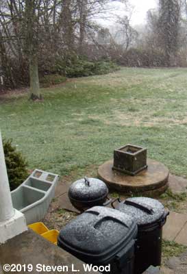 Snow on grill and trash cans