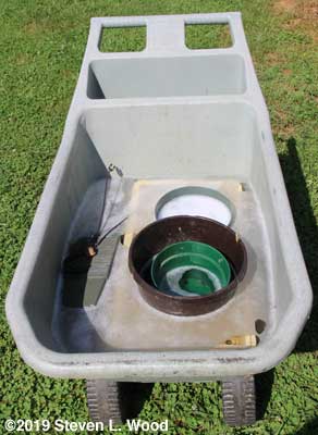 Garden cart filled with trays, pots, and bleach water