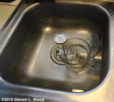 Measuring cup in hot water bath in sink